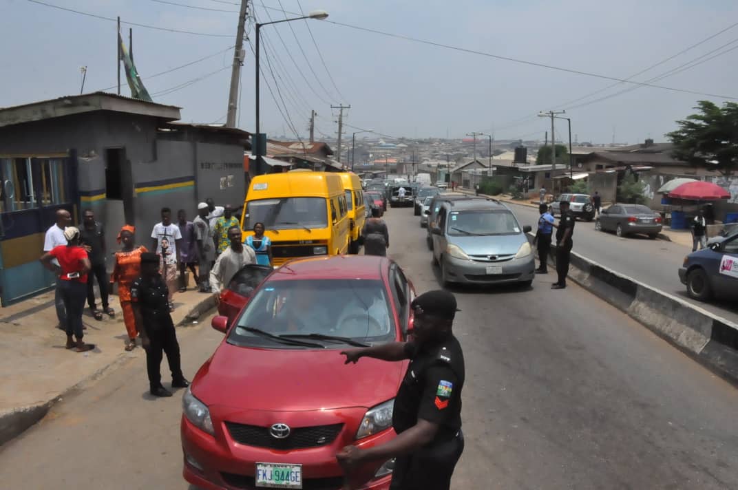 Police officers block road and checking vehicles at Ile-Iwe, bus stop, along Ekoro